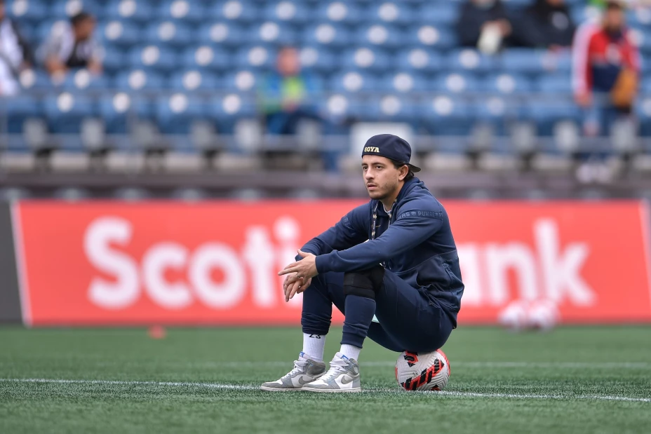 Alan Mozo sentado en un balón de futbol durante un entrenamiento con Pumas