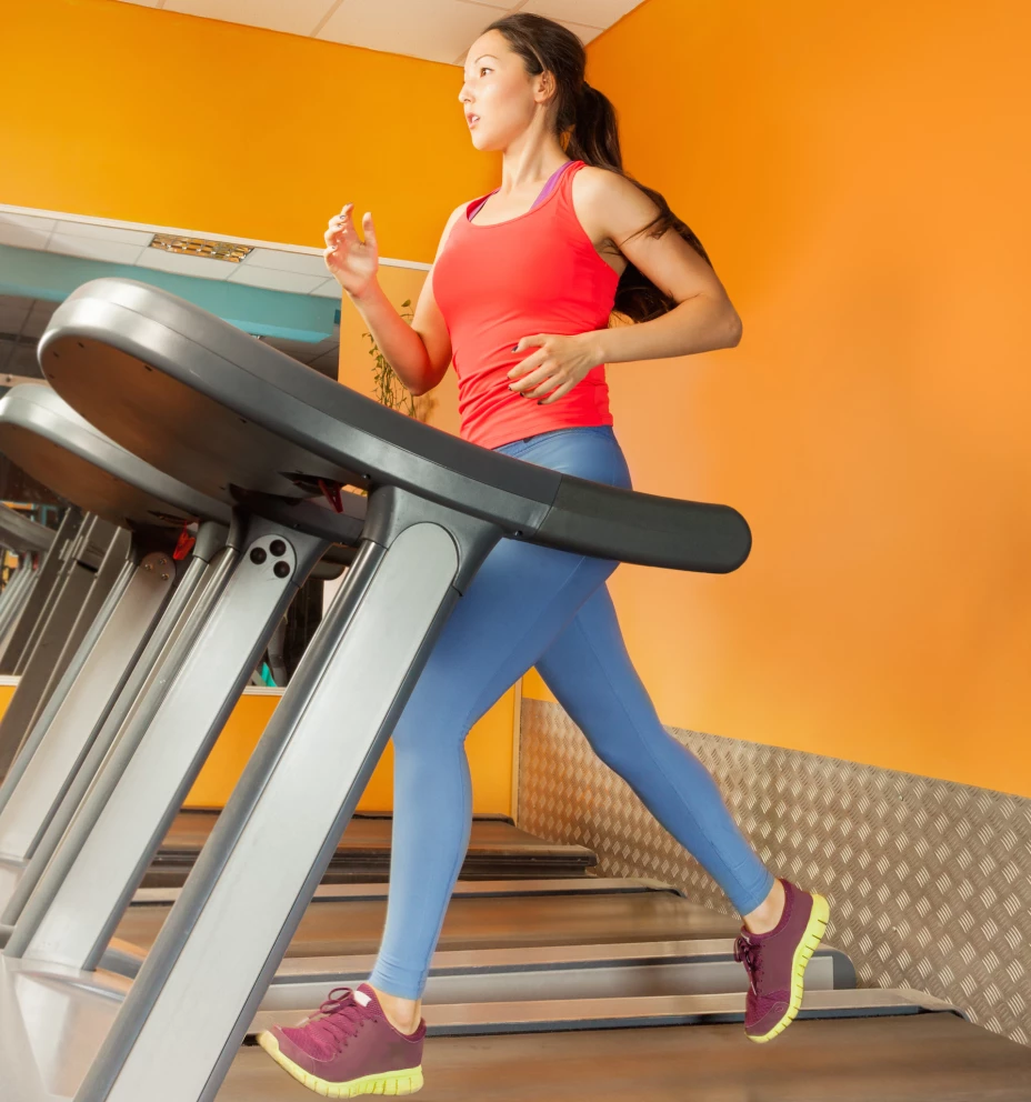 Attractive Asian girl running on the treadmill