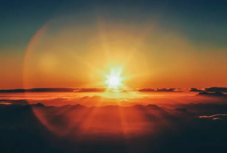 La puesta de sol sobresaliendo sobre el horizonte.