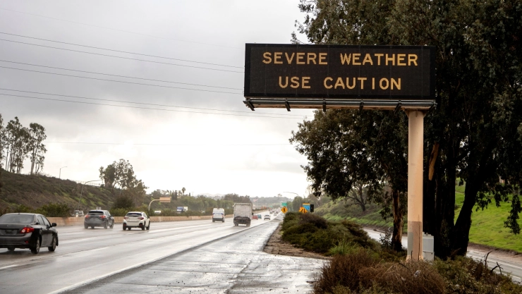 Letrero de precaución en carretera de San Diego, California, mojada por la luvia