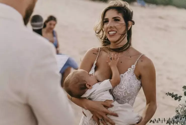 Mujer amamanta a su bebé en medio de su boda.jpg