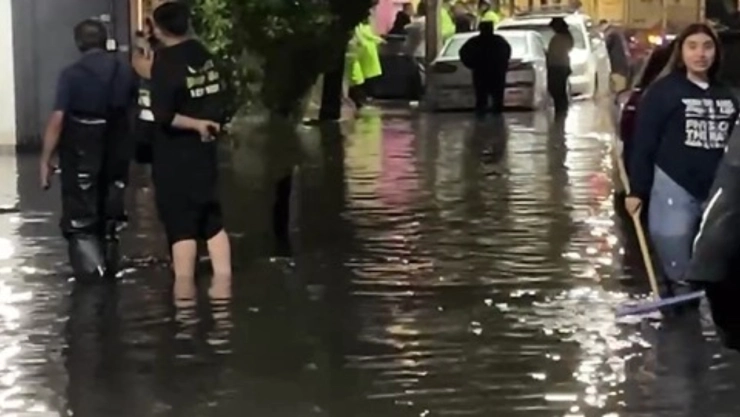 ¿Qué infecciones y enfermedades pueden afectarte tras inundaciones de aguas negras? En la imagen se observa a personas afectadas por el diluvio, exponiéndose a la combinación del agua de lluvia con aguas negras.