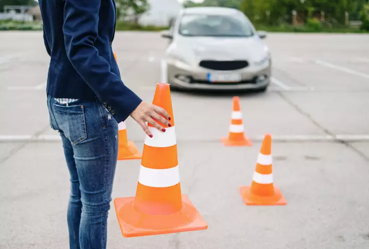 Driving school or test. Beautiful young woman learning how to drive car together with her instructor.