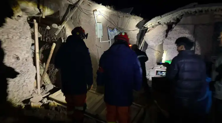 Bomberos inspeccionan viviendas tras un sismo en Nagqu, China.