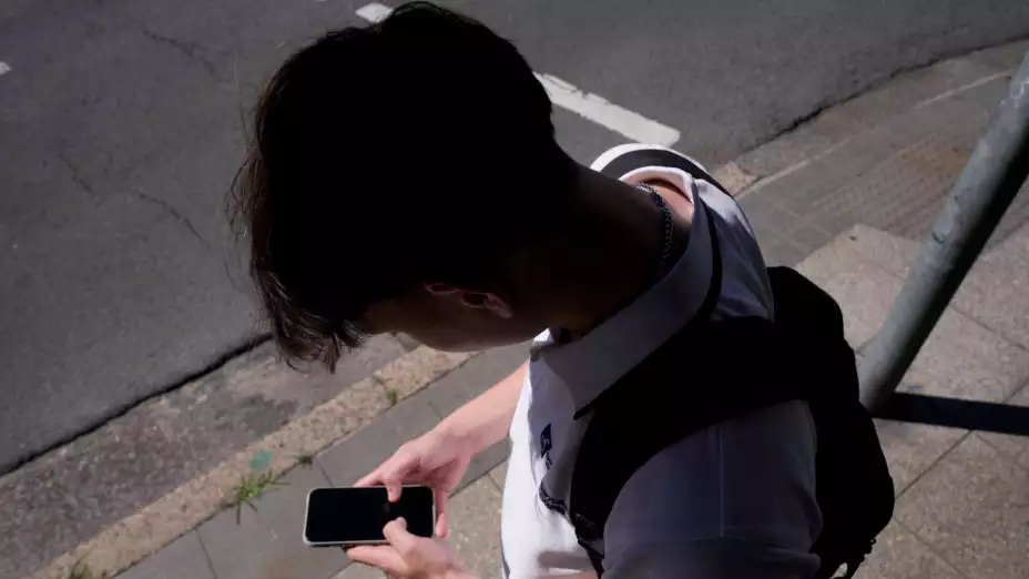 Un adolescente mira su teléfono en Sydney, Australia
