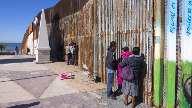 Migrantes en el muro fronterizo entre México y EU.