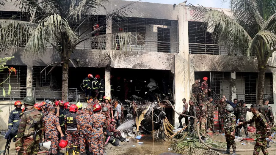 Bomberos y soldados trabajan junto a los restos de un avión de entrenamiento de la fuerza aérea después de que se estrellara en el campus de Milestone College, en Daca, Bangladesh , el 21 de julio de 2025