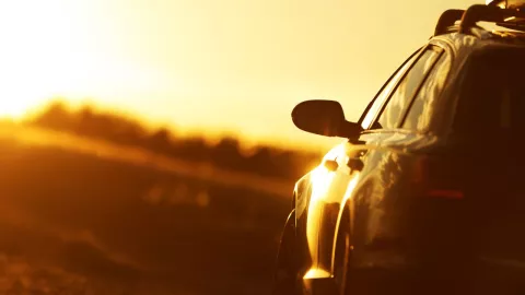 en el horizonte se observa un fuerte rayo de sol y en la parte inferior derecha un carro