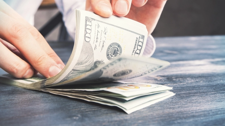 Una persona cuenta billetes de dólares