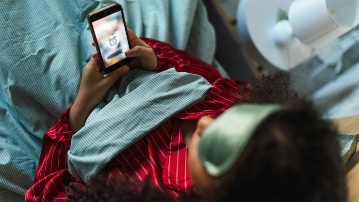una mujer pone su alarma para irse a dormir
