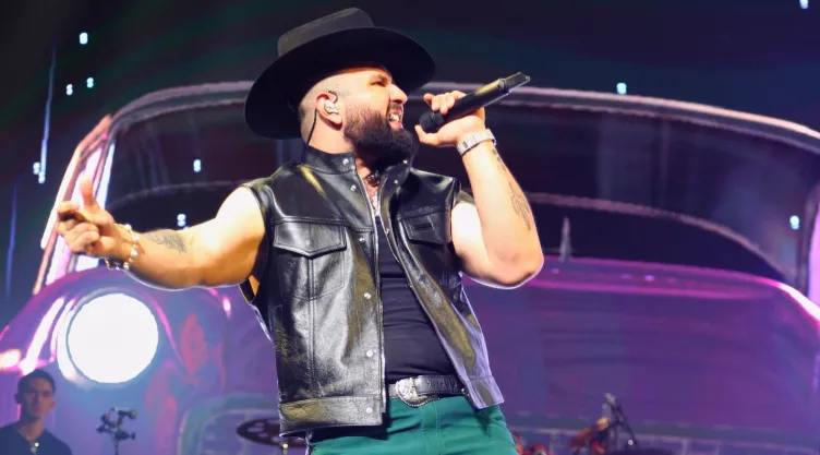 Carín León cantando en el escenario de Kaseya Center de Miami