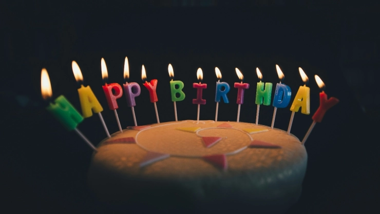Pastel con velas de Feliz Cumpleaños.