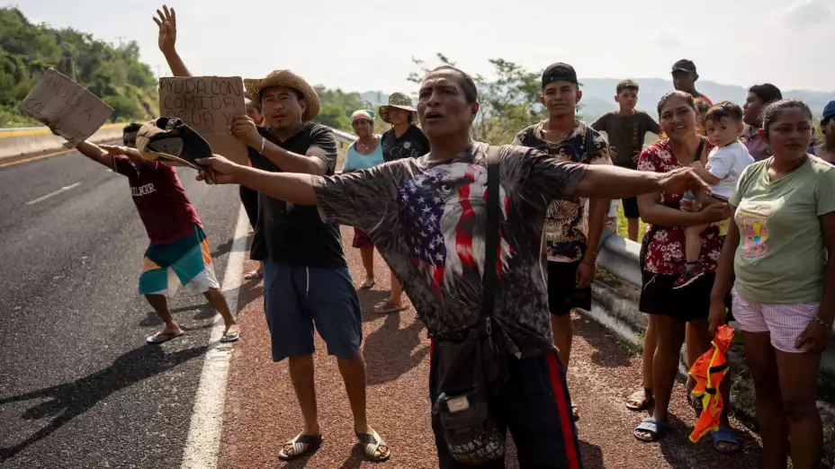 Personas de Acapulco afectadas por huracán Otis piden ayuda en la carretera.