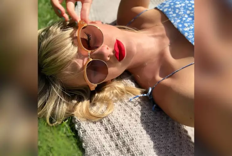 Taylor Swift recostada en el pasto con lentes de sol.