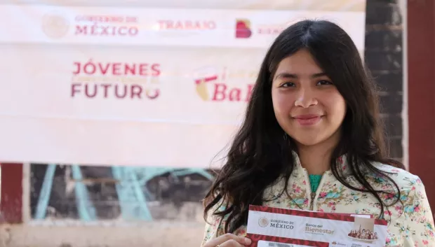 jóven mostrando su sobre que la acredita como beneficiaria del programa Jóvenes Construyendo el Futuro