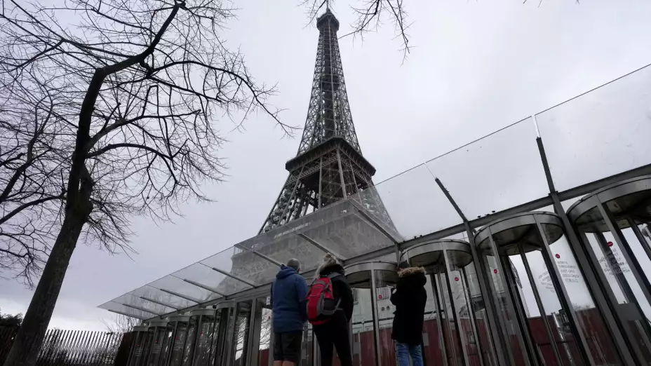 Visitantes frente a las puertas cerradas de la Torre Eiffel.