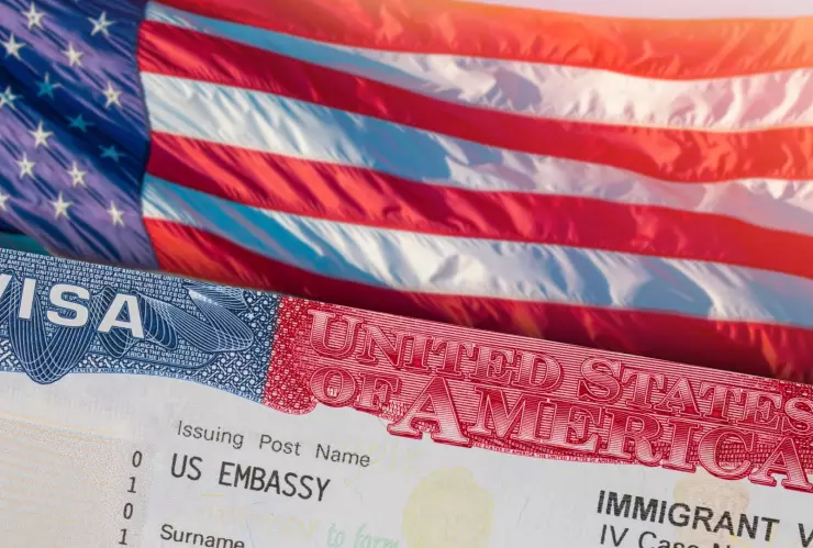 Una visa americana sobre una bandera estadounidense.