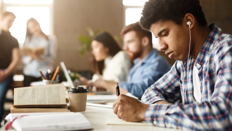 un joven estudia con auriculares puestos