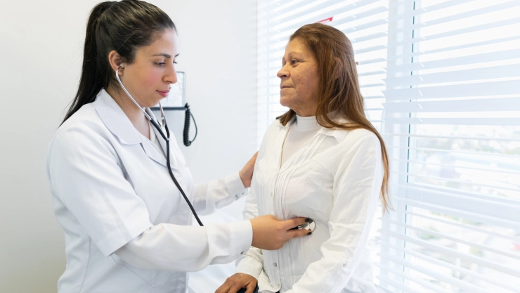 Una profesional de la salud ausculta a una paciente