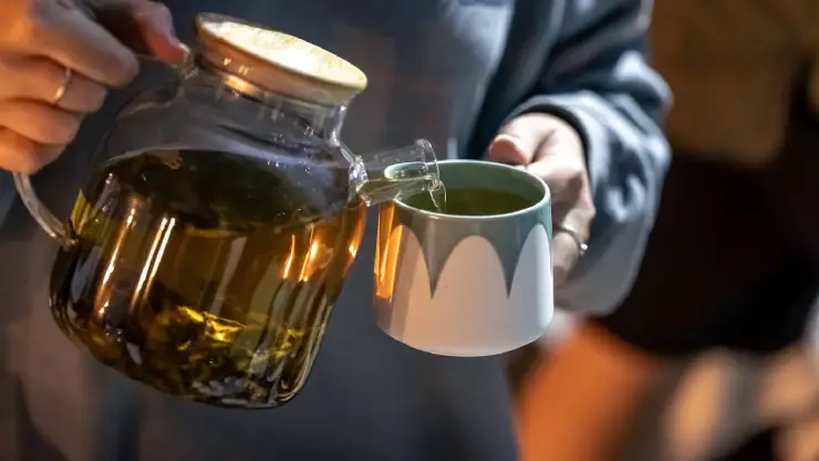 una mujer se sirve una taza de té