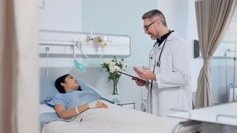 Un médico atiende a una paciente en un hospital.