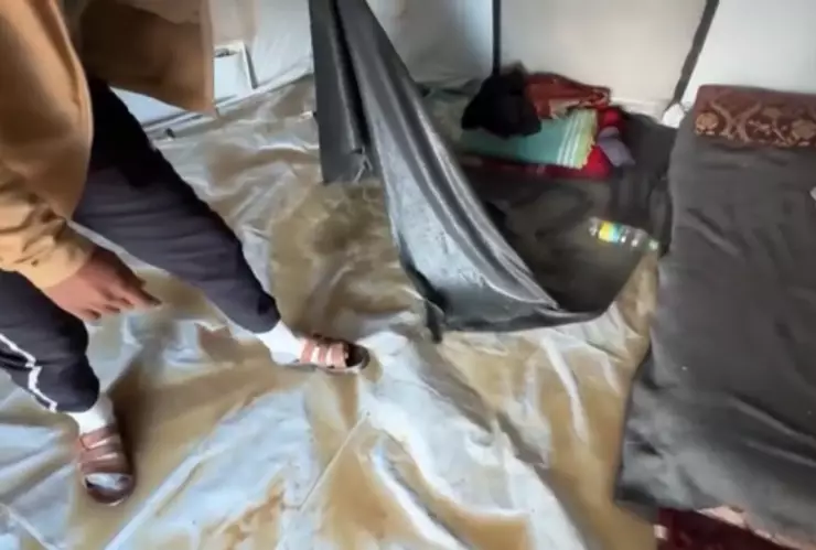 Un hombre palestino muestra el interior de su casa de campaña inundada en la Franja de Gaza