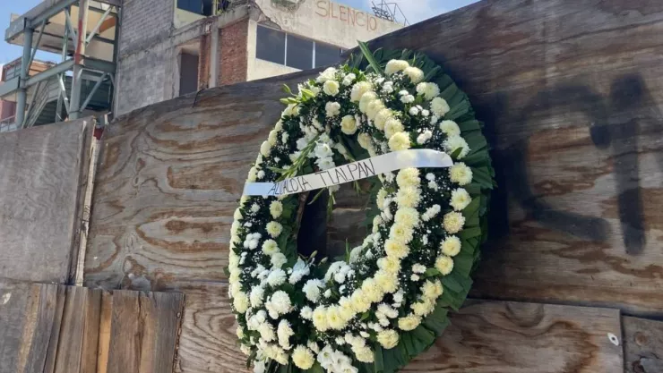 coronas de flores blancas y otros ramos adornan las tablas de madera a las afueras del Colegio Rébsamen