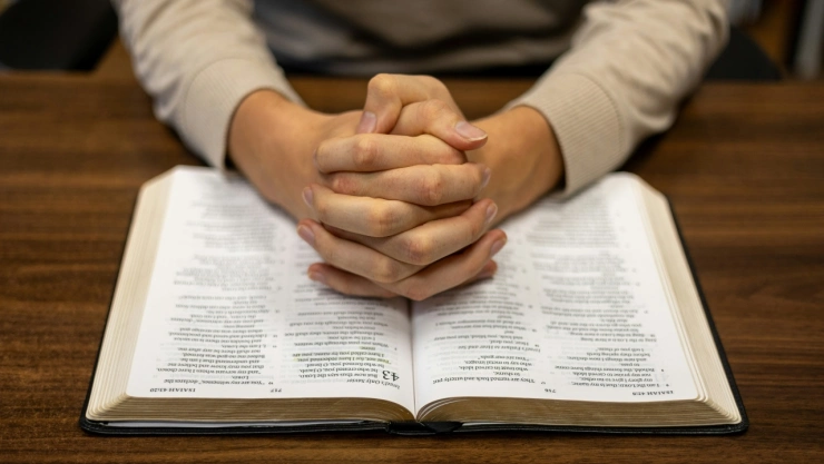 Persona orando frente a biblia.