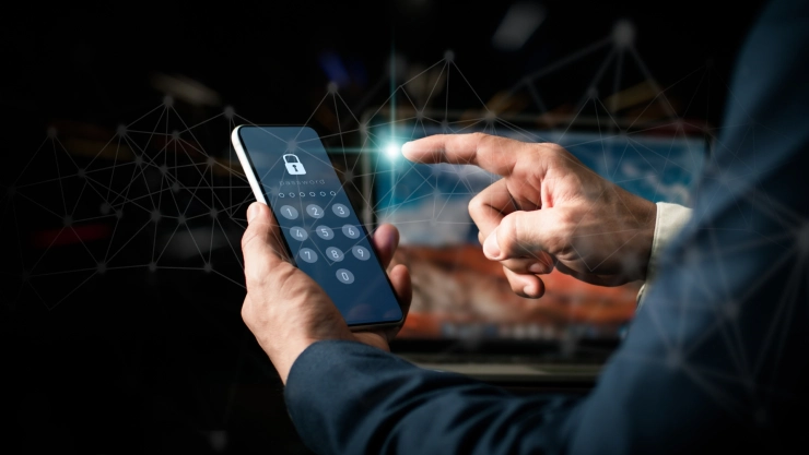 Un hombre de traje desbloqueando su dispositivo celular con la contraseña de seis dígitos