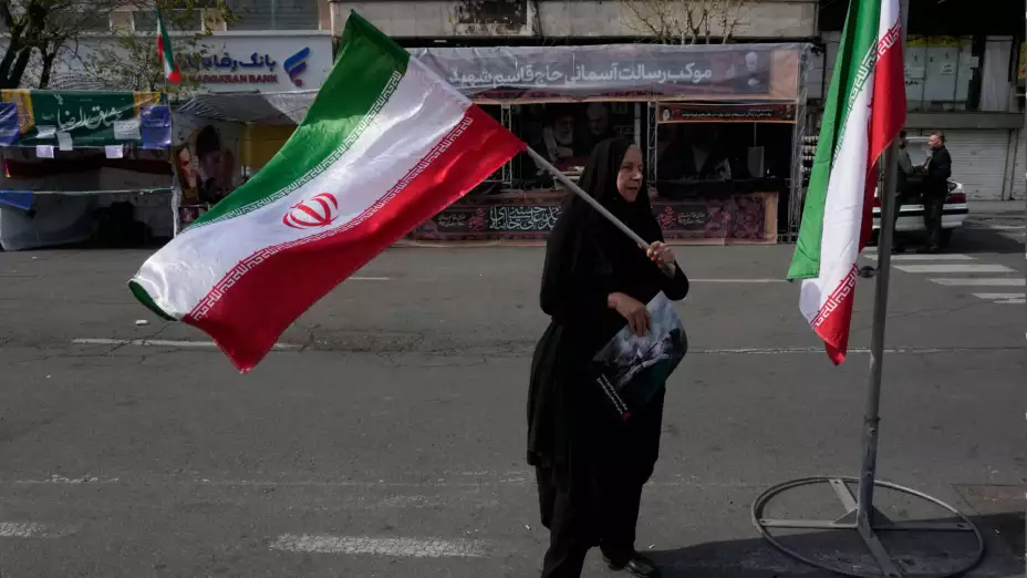 Una mujer ondea una bandera iraní en Teherán, Irán.