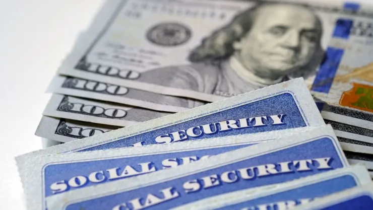 Una tarjeta de la Seguridad Social sobre billetes de 100 dólares.