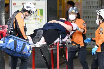 Rescatistas sacan a una persona herida de un centro comercial en Corea del Sur.