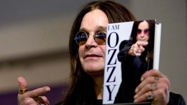 Ozzy Osbourne mostrando un ejemplar de su libro autobiográfico.