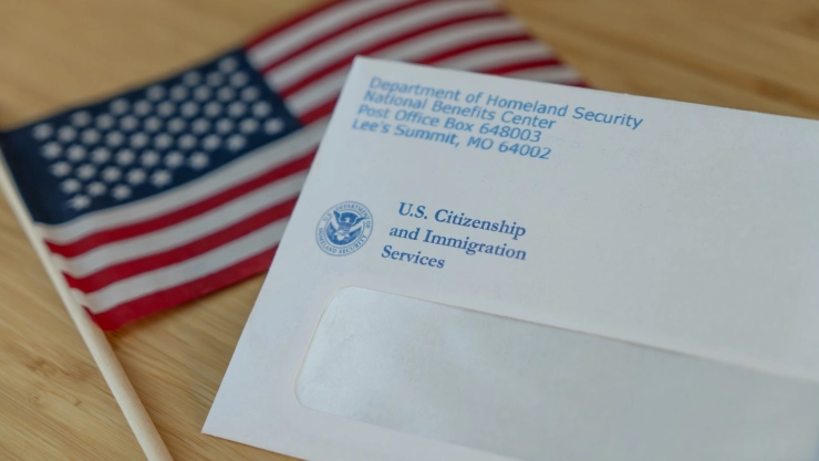 Un sobre del USCIS sobre una bandera estadounidense.