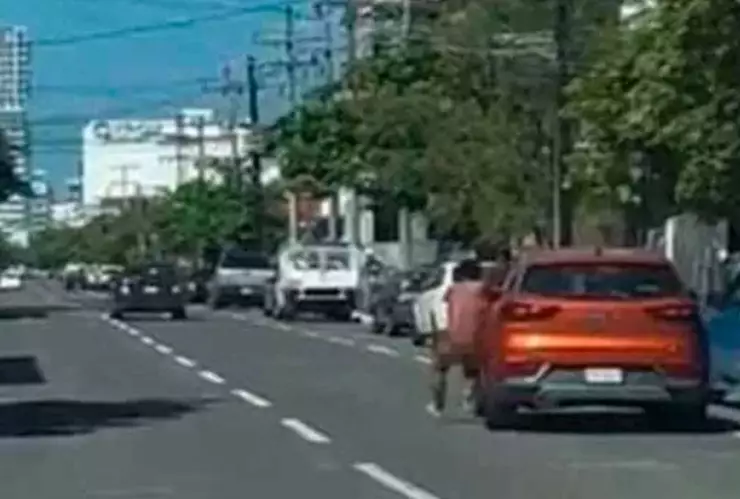 Hombre desnudo cuelga de auto en movimiento