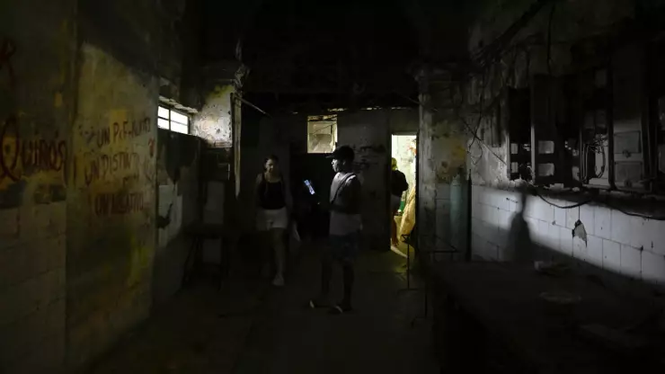 La gente camina por un pasillo después de que se restableció la energía tras un colapso parcial de la red eléctrica que dejó a gran parte del oeste de Cuba a oscuras, en La Habana, Cuba , el 3 de diciembre de 2025