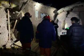 Bomberos inspeccionan viviendas tras un sismo en Nagqu, China.