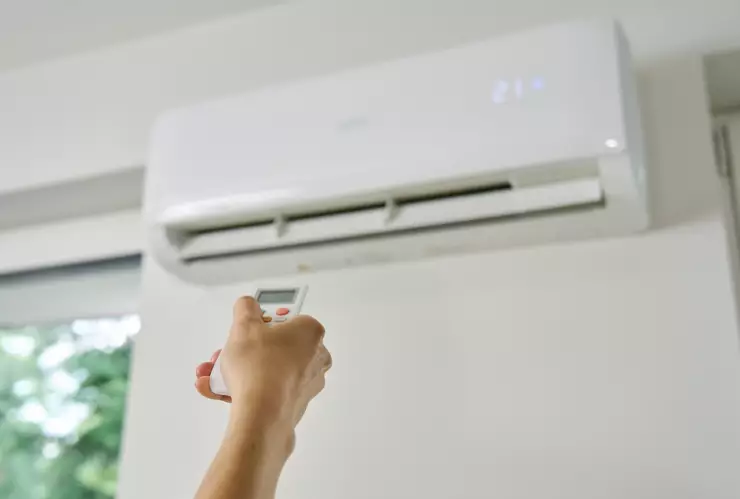 Una persona enciende un aire acondicionado