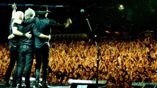 Soda Stereo en el escenario con el público de frente.