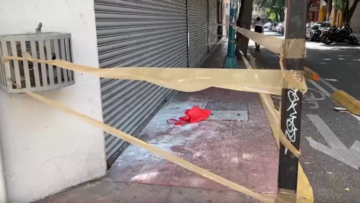 exterior de la casa de empeño, acordonada por cinta canela; en el piso son visibles algunos vidrios y una bolsa roja