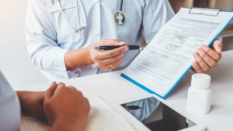 Una persona muestra la planilla de seguro médico a un paciente