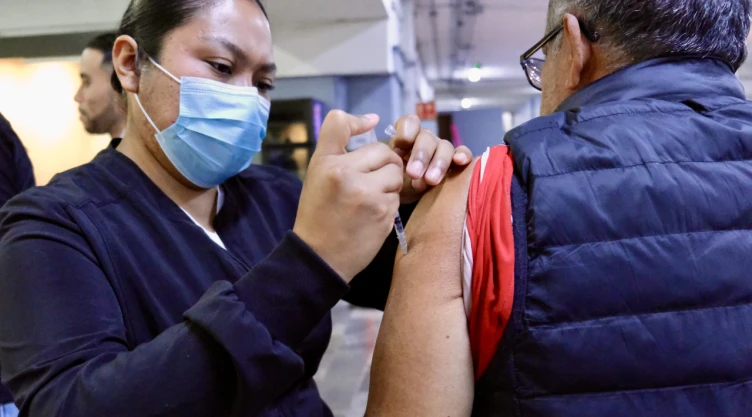 Enfermera de la secretaría de salud de Jalisco vacunando a un hombre contra el sarampión