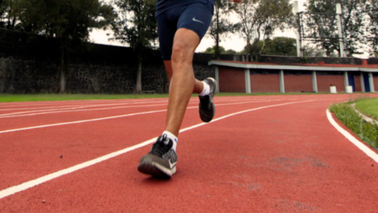 Persona corriendo sobre una pista de atletismo