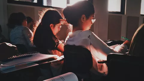 estudiantes tomando apuntes durante una clase en la escuela