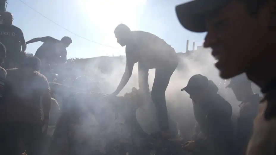 Palestinos reparan un auto dañado tras un bombardeo israelí en Gaza.