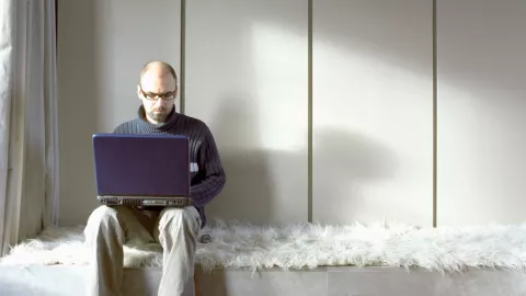 Man on Laptop in Lounge Room