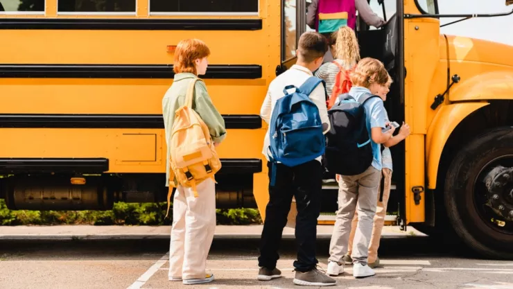 Unos jóvenes subiendo a un bus escolar.
