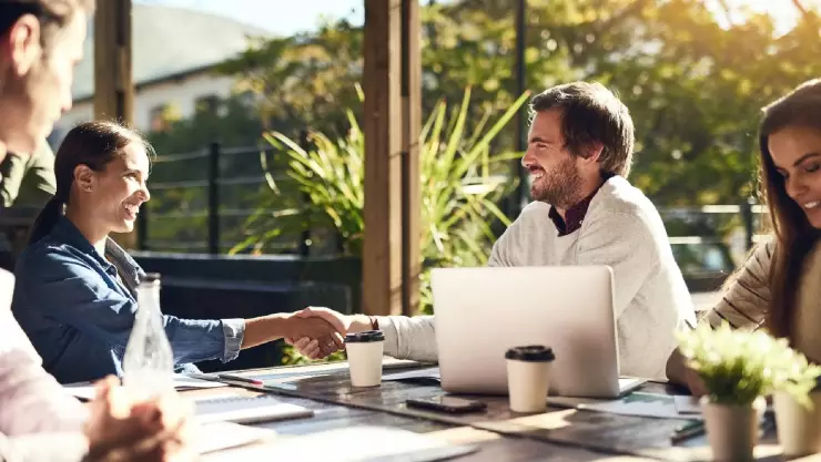 un grupo de gente trabaja felizmente en equipo