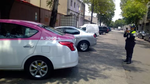 oficial de tránsito tomando una fotografía a un carro