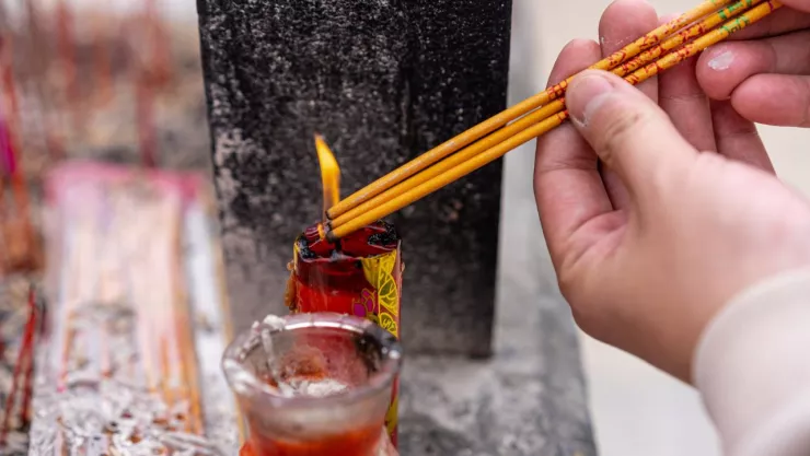 encendiendo una vela en un vasito rojo